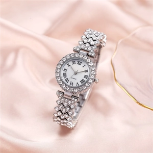Detail of luxury rhinestone silver quartz watch on soft pink silk background