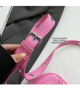 Gros plan du sac coeur rose avec boucle métallique argentée ajustable sur la bandoulière