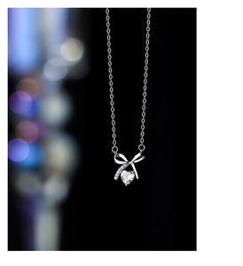 Close-up of S925 silver knot bow necklace with heart-shaped clear cubic zirconia