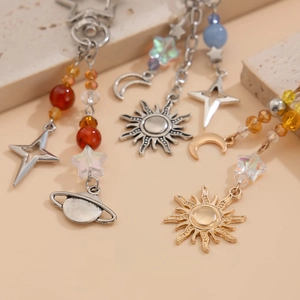 Macro detail of celestial sun moon and planet charms with colorful beaded metal chains