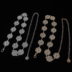 Detail of four gold and silver metal waist chains with flower and circle patterns