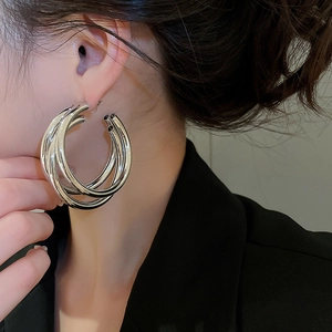 Close-up of a silver multi-layered hoop earring worn by a model for a stylish look
