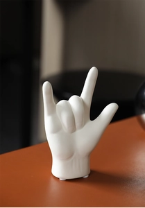 Close-up of matte white ceramic hand sculpture showing detailed texture for home decor