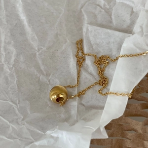Detailed view of 925 sterling silver ball necklace with textured golden bead pendant
