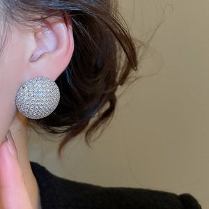 Gros plan de boucles d'oreilles rondes en zircone portées par un mannequin