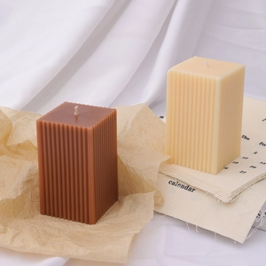 Detail of vertical striped texture on brown and cream square pillar scented candles