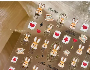 Macro detail of vintage rabbit nail stickers with poker and tea cup motifs on fabric