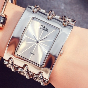 Silver quartz watch with wide rectangular dial and thick chain strap worn on wrist