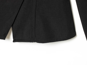 Close-up of black blazer hem showing premium twill fabric texture and neat stitching