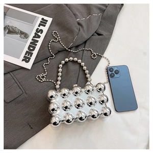 Detailed view of silver metallic beaded box bag with pearl handle and shoulder chain