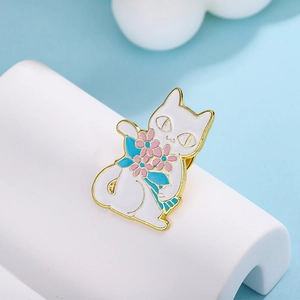 Cartoon white cat enamel brooch holding pink flower bouquet with gold plating on blue background