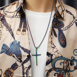 Close-up of a rainbow-plated stainless steel cross necklace worn by a model