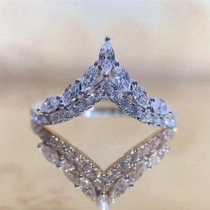 Elegant V-shaped heart crown ring with marquise-cut white crystals on golden reflective surface