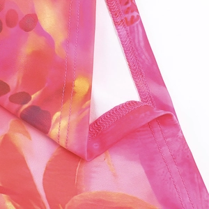 Détail de la robe à imprimé dégradé rose et orange avec des coutures de finition de qualité