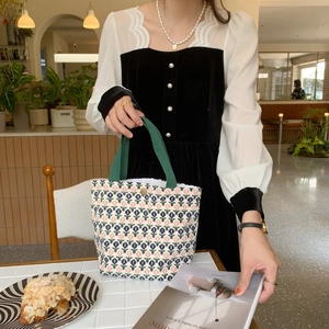 Detail of vintage knit corduroy tote bag with tulip patterns in a cozy cafe setting