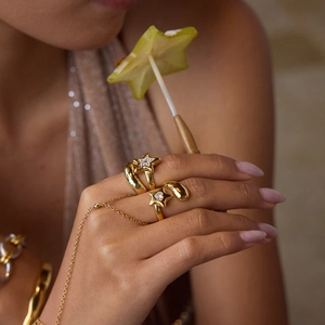 Detailed view of a gold star ring set with crystals and a matching delicate bracelet