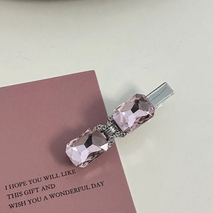 Macro shot of pink rhinestone hair clip with crystal bow and silver duckbill base