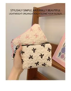 Close-up of quilted cotton cosmetic bags with bow patterns and pearl zipper charms