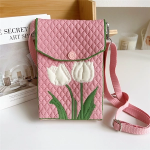 Detail of pink knitted crossbody bag featuring a tulip pattern and adjustable strap
