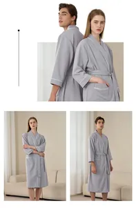 Detail of grey waffle-knit robe with white contrast piping and tie-waist closure
