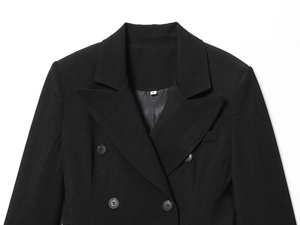 Detail of the neckline and double-breasted buttons on a black structured blazer dress
