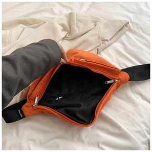 Detailed interior of orange nylon crossbody bag with zipper pocket and branded strap