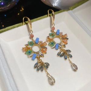 Detail of bohemian flower earrings with colorful beads and crystal drops in a box