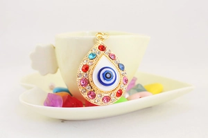 Macro shot of evil eye pendant with colorful rhinestones on a decorative dish