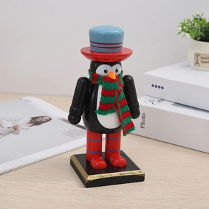 Detailed view of penguin-shaped wooden nutcracker with red and green knitted scarf