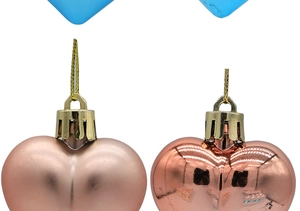 Close-up of pink heart Christmas ornaments showing matte and glossy plated finishes