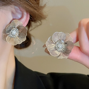 Elegant gold flower stud earrings with hollow petal texture and crystal center detail