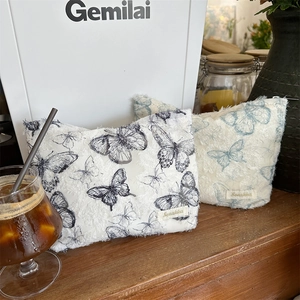 Close-up of lace butterfly makeup pouch with textured jacquard fabric and raw edge details