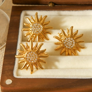 Three gold sun-shaped rings with crystal rhinestones in a wooden jewelry gift box