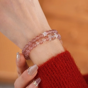 Double-layer strawberry quartz beaded bracelet with silver crown charms on female wrist