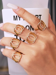 Detailed view of five golden double-loop rings with white zircon on an elegant hand