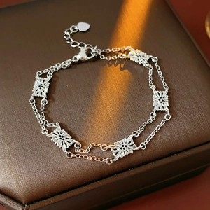 Detailed close-up of a silver hollow floral bracelet on a brown leather jewelry box