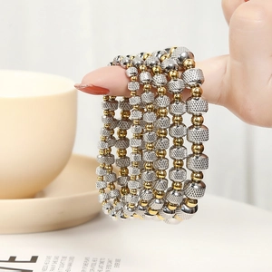 Two-tone stainless steel elastic bead bracelet with gold beads and grid pattern silver cylinders