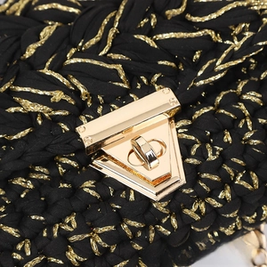 Macro detail of hand-crocheted black cotton handbag with gold metallic thread and clasp