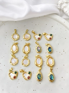 Detailed view of assorted 18k gold-plated heart and oval charms with colorful shell inlays