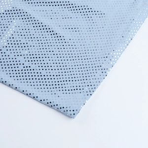 Detailaufnahme von hellblauem Stoff mit silbernen Pailletten und feinen Nähten
