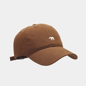 Detailed view of white polar bear embroidery on brown cotton baseball cap