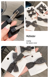 Close-up of black rhinestone bow hair clips showing metallic alligator grip detail