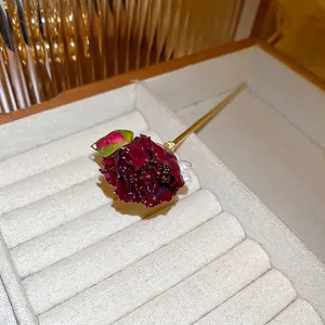 Forcina vintage con rosa rossa e perla e asta in metallo dorato su velluto beige
