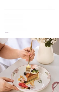 Close-up of ceramic bowl with pink floral underglaze pattern and hand holding a fork