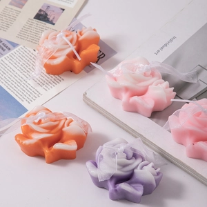 Detailed view of layered carnation scented candles in orange, pink and purple gradients