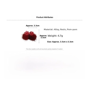 Detailed view of red resin flower earrings with soft pompom drops and silver needles