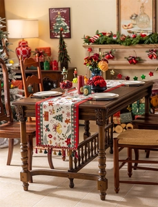 Close-up of festive Christmas table runner featuring jacquard trees and elegant tassels