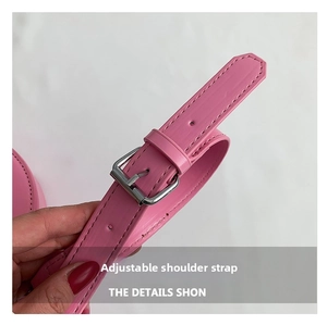 Close-up of adjustable bright pink faux leather shoulder strap with silver buckle detail