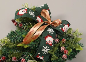 Dettagli della ghirlanda natalizia con nastri di Babbo Natale e bacche rosse decorative