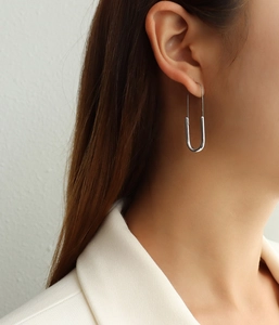 Close-up of minimalist silver paperclip earrings on model showing sleek U-shaped metal